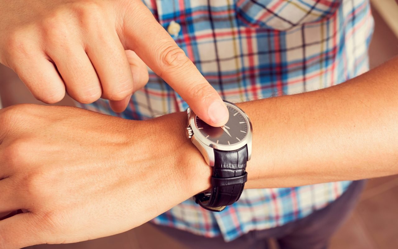 Jeune homme tapotant avec son doigt sur sa montre